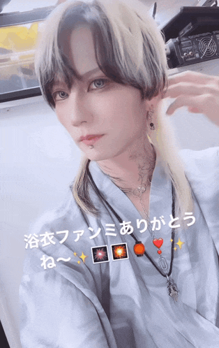 a man with a tattoo on his neck is wearing a kimono and earrings