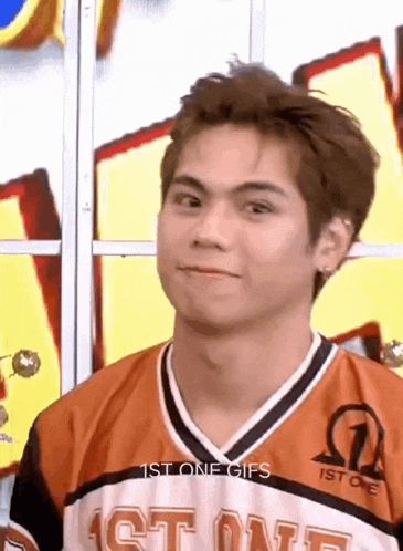 a young man wearing a jersey that says 1st one is making a funny face .
