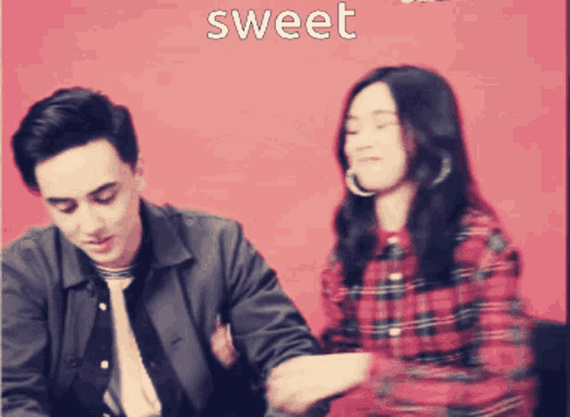 a man and a woman are sitting in front of a red background with the word sweet on it