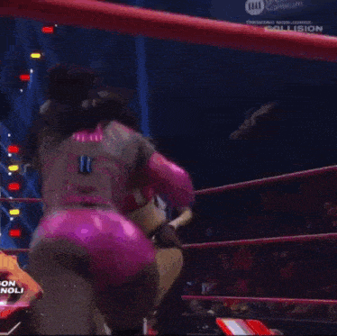 a wrestler is laying on the ground in a ring with a aew logo on the wall behind her