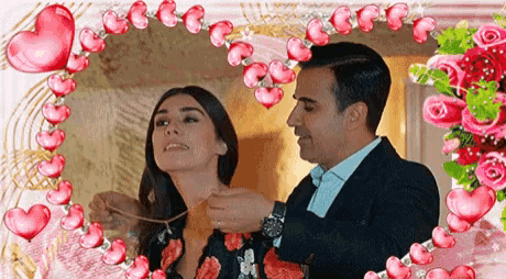 a man is putting a necklace on a woman 's neck surrounded by hearts and flowers