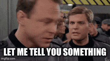 two men are standing next to each other and one of them is saying " let me tell you something "