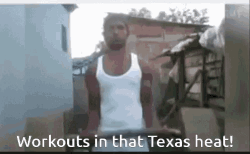 a man in a white tank top is doing exercises in the heat