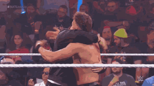 two men in a wrestling ring with the words nxt level up on the bottom right