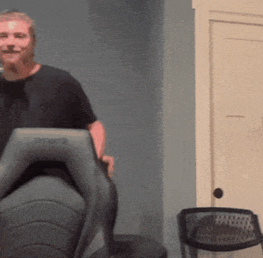 a man in a black shirt is sitting in a chair that has the word degree on it