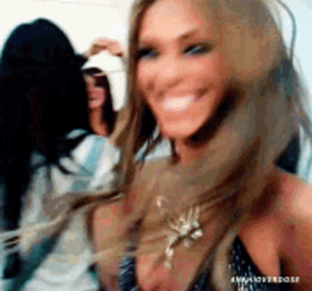 a woman with long hair is smiling and looking at the camera .