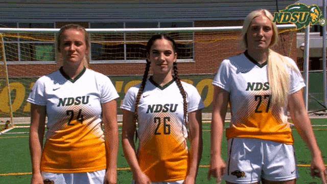 three female soccer players for ndsu are standing next to each other