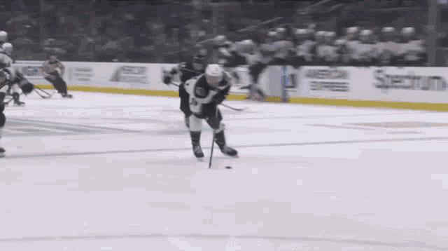 a hockey game is being played in front of a sign for geico