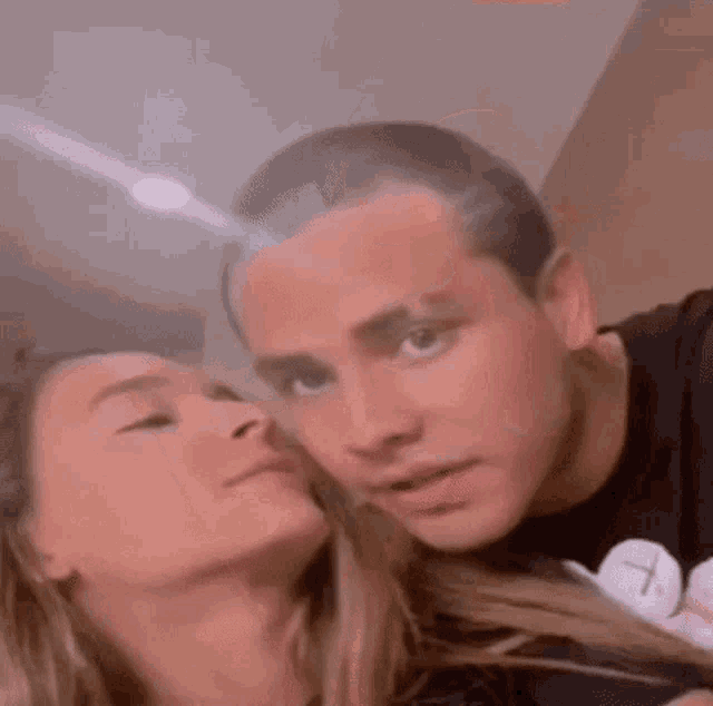 a man and a woman are looking at each other with their eyes closed .
