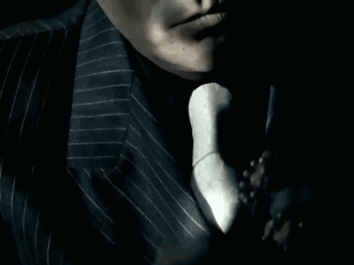 a man in a suit and tie holds his hand to his mouth