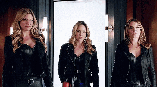 three women in leather jackets are standing next to each other in a doorway .