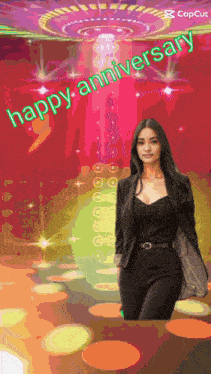 a woman in a black suit is standing in front of a colorful background that says " happy anniversary "
