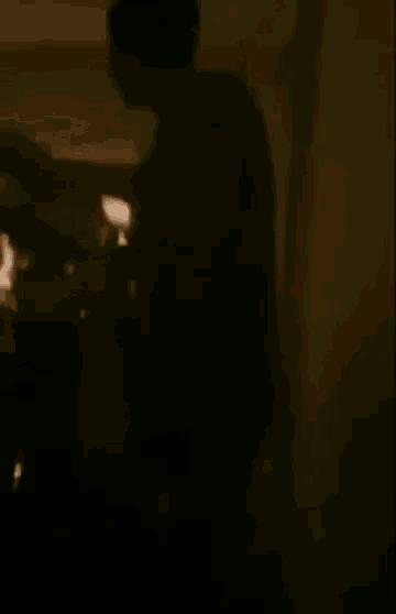 a man is standing in front of a mirror in a room and looking at himself in the mirror .
