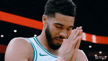 a basketball player praying with a netflix logo in the corner