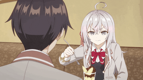 a girl is holding a spoon in front of a man who is eating a dessert