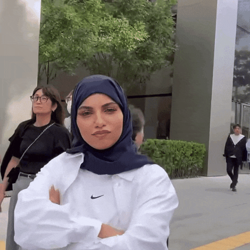 a woman wearing a blue hijab and a white nike shirt