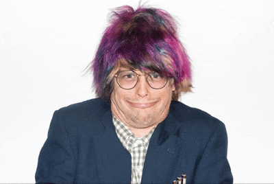 a man wearing glasses and a purple wig makes a funny face
