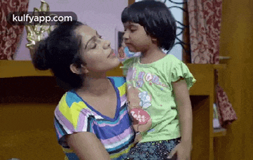 a woman is holding a little girl in her arms .