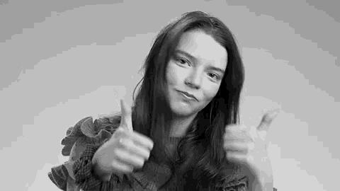 a black and white photo of a woman giving a thumbs up sign .
