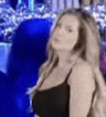 a woman in a black tank top is standing in front of a blue light .