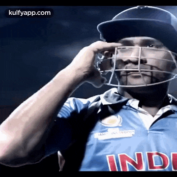 a man wearing a helmet and a blue shirt with the word india on it