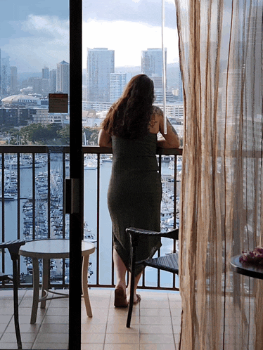 a woman standing on a balcony with a sign on the window that says ' no smoking ' on it