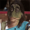 a woman with a frog mask on her face is sitting in a chair .