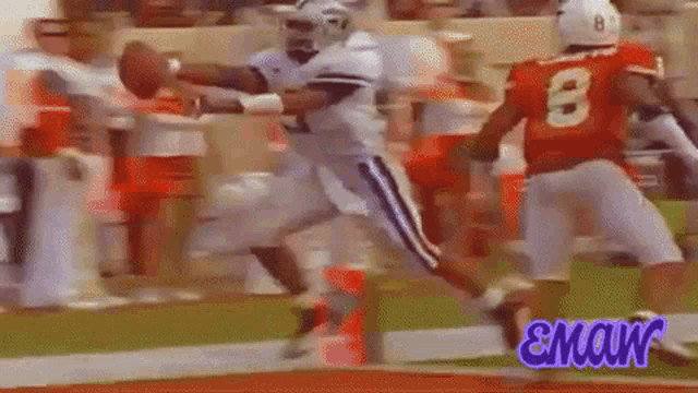 a football player with the number 8 on his jersey catches a ball