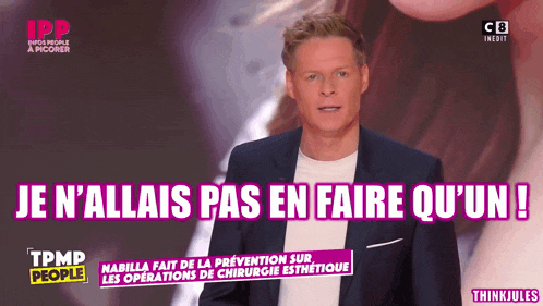 a man in a suit stands in front of a sign that says je n'allais pas en faire qu'un !