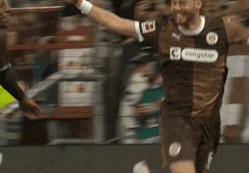 a soccer player wearing a congstar jersey celebrates