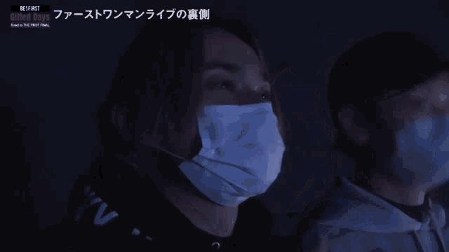 a man wearing a mask is watching united boys perform