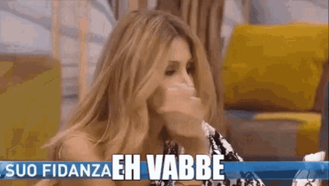 a woman is covering her mouth with her hand and the words suo fidanza eh vabbe are behind her
