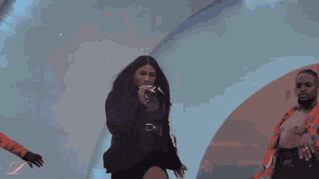 a woman is singing into a microphone while smoke is coming out of her mouth .