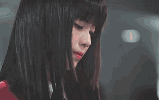 a close up of a woman 's face with long dark hair