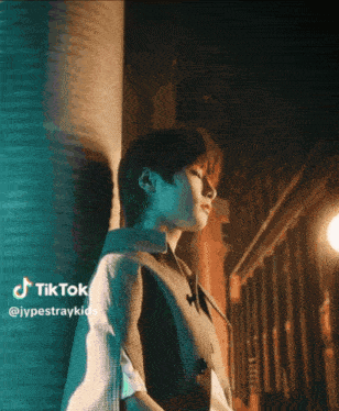 a young man leaning against a wall with a tiktok watermark in the corner
