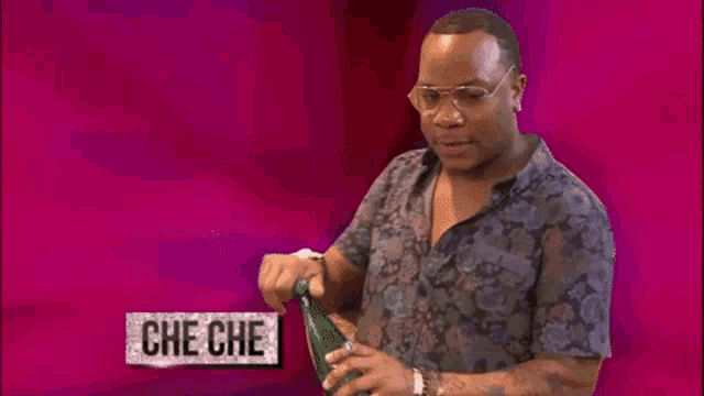 a man in a floral shirt is opening a bottle with the name che che written on the bottom