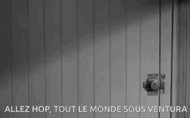 a black and white photo of a door with the words allez hop tout le monde sous ventura below it