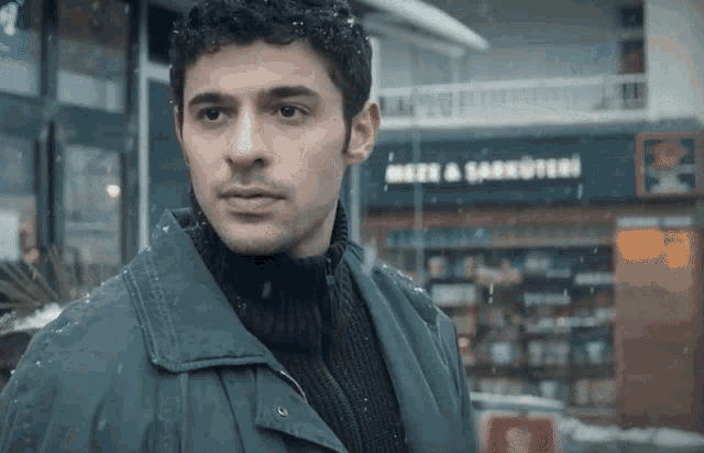 a man stands in front of a store that says meze & sakruteri