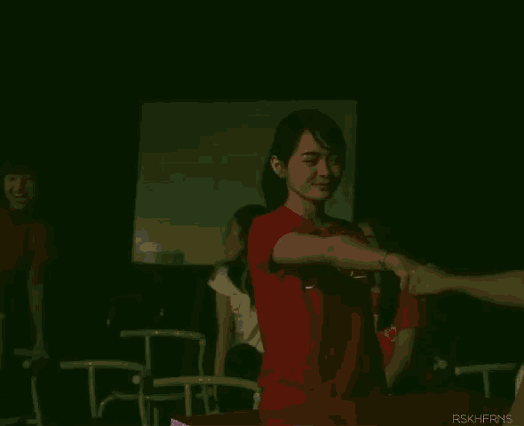 a woman in a pink shirt is dancing in front of a blue light .