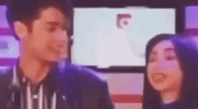 a man and a woman are standing next to each other .