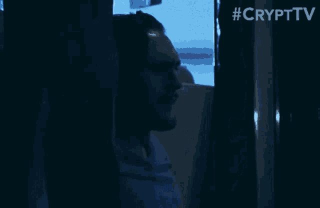a man is standing in a dark room with the hashtag #crypttv behind him
