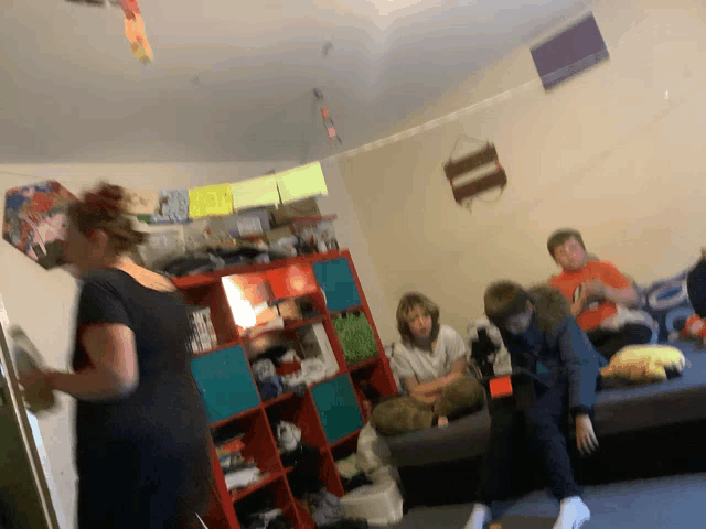 a group of people are gathered in a living room with a sign on the wall that says ' i love you '