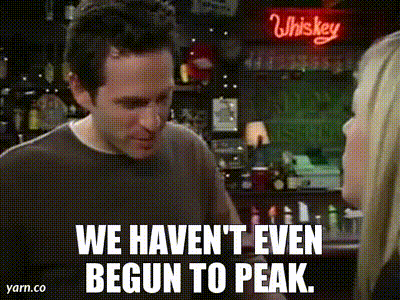 a man and a woman are standing in front of a whiskey sign and talking to each other .