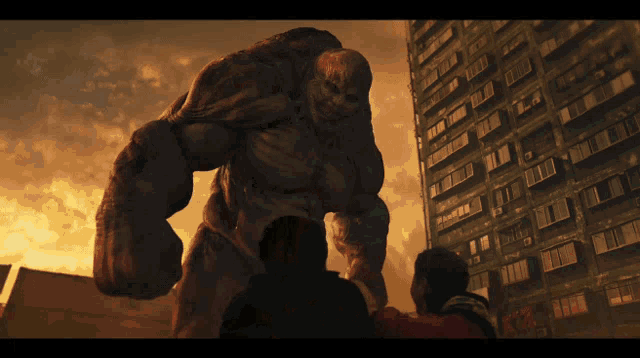 a giant monster is standing in front of a building with a sign on it that says ' a '