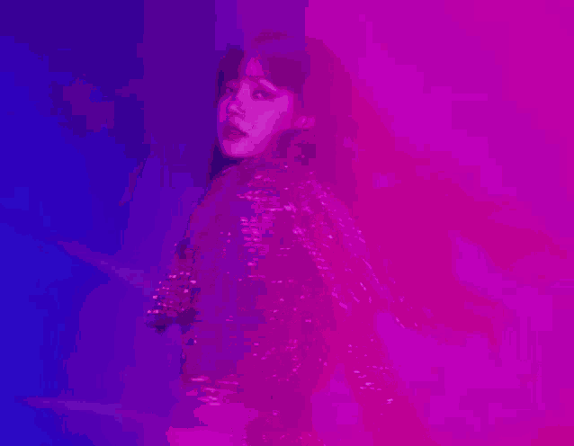 a woman is standing in front of a purple and blue background .