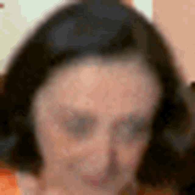 a blurry picture of a woman 's face with a lot of spots on her face .