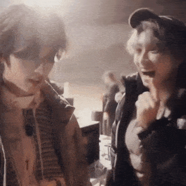a man and a woman are standing next to each other in a room and laughing .