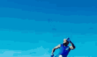 a man in a blue shirt and blue shorts is throwing a ball
