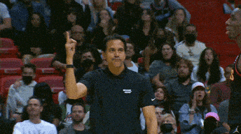 a man in a black shirt with the word miami on it stands in front of a crowd