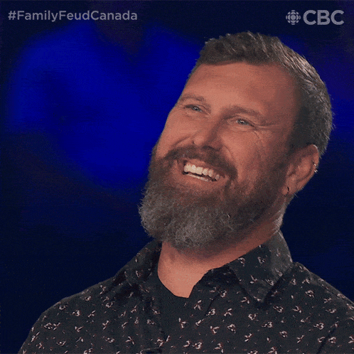 a man with a beard is smiling in front of a blue background that says cbc